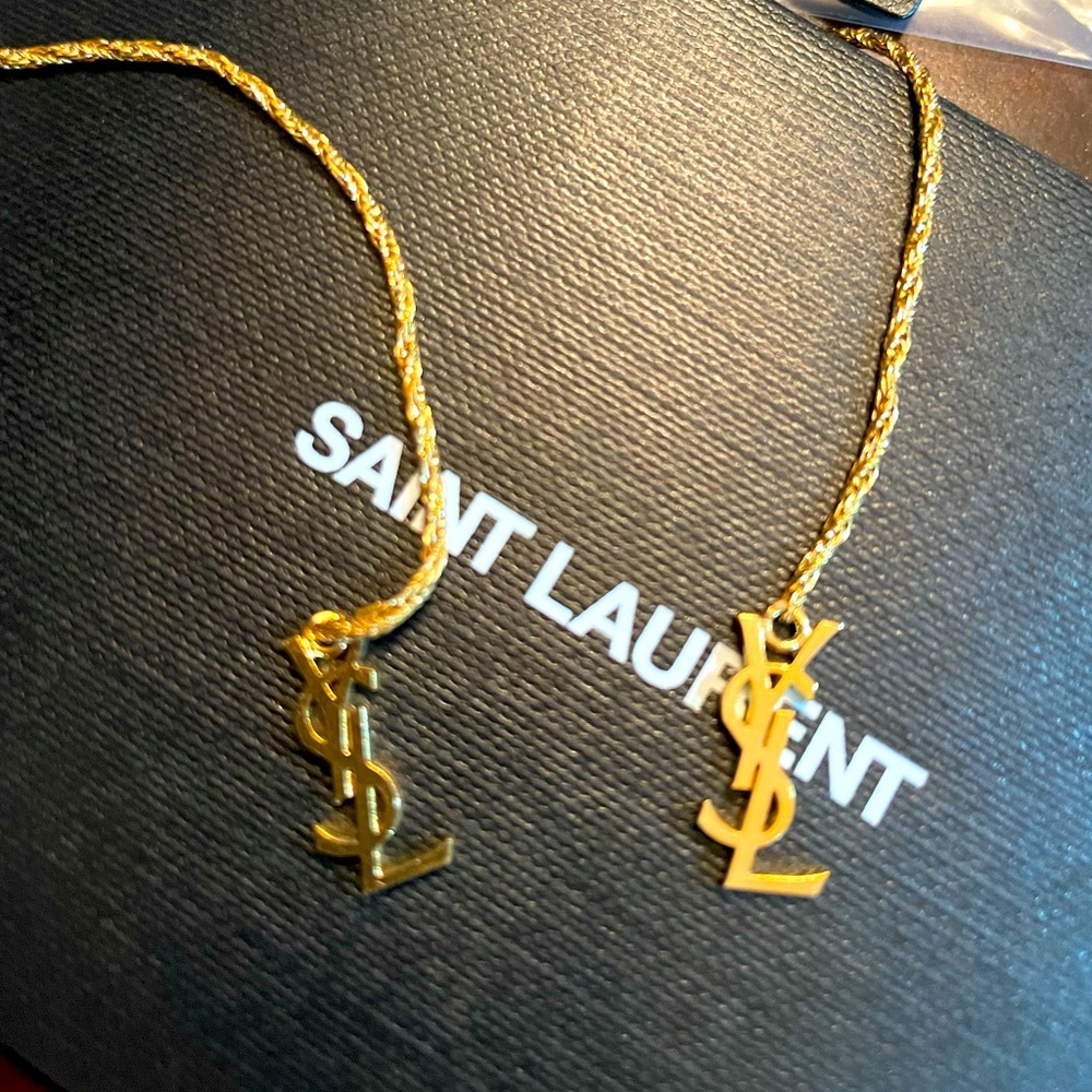 Beautiful gold YSL logo dangle clip on earrings .